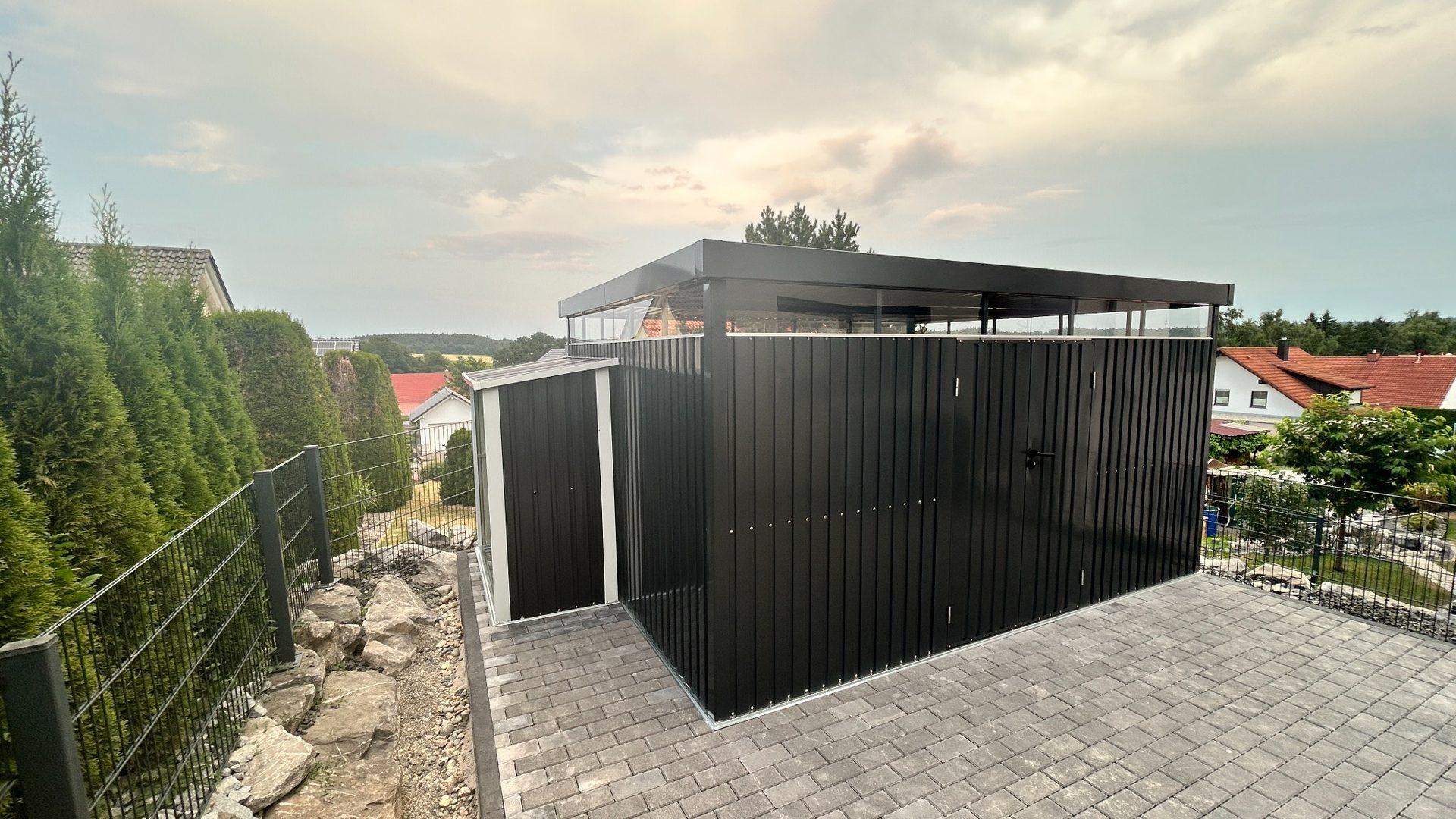 Moderne Gartenhütte mit Pflasterfläche und Außenanlage