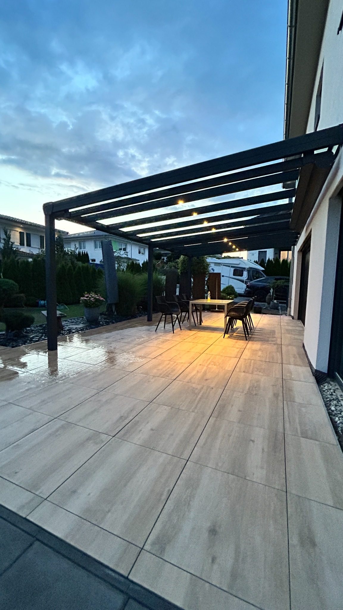 Moderne Terrasse mit Terrassenüberdachung und stimmungsvoller Beleuchtung am Abend.