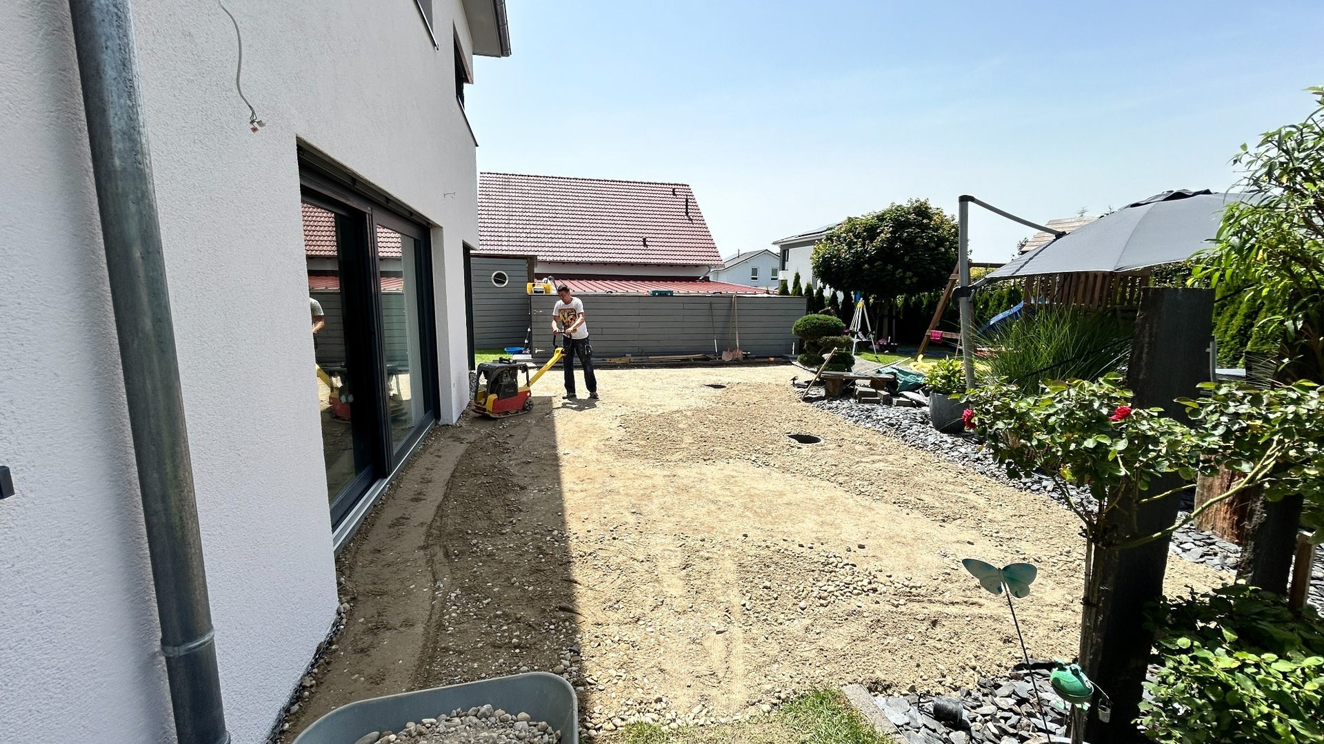 Untergrundvorbereitung für eine Terrasse mit verdichteter Tragschicht am Haus.